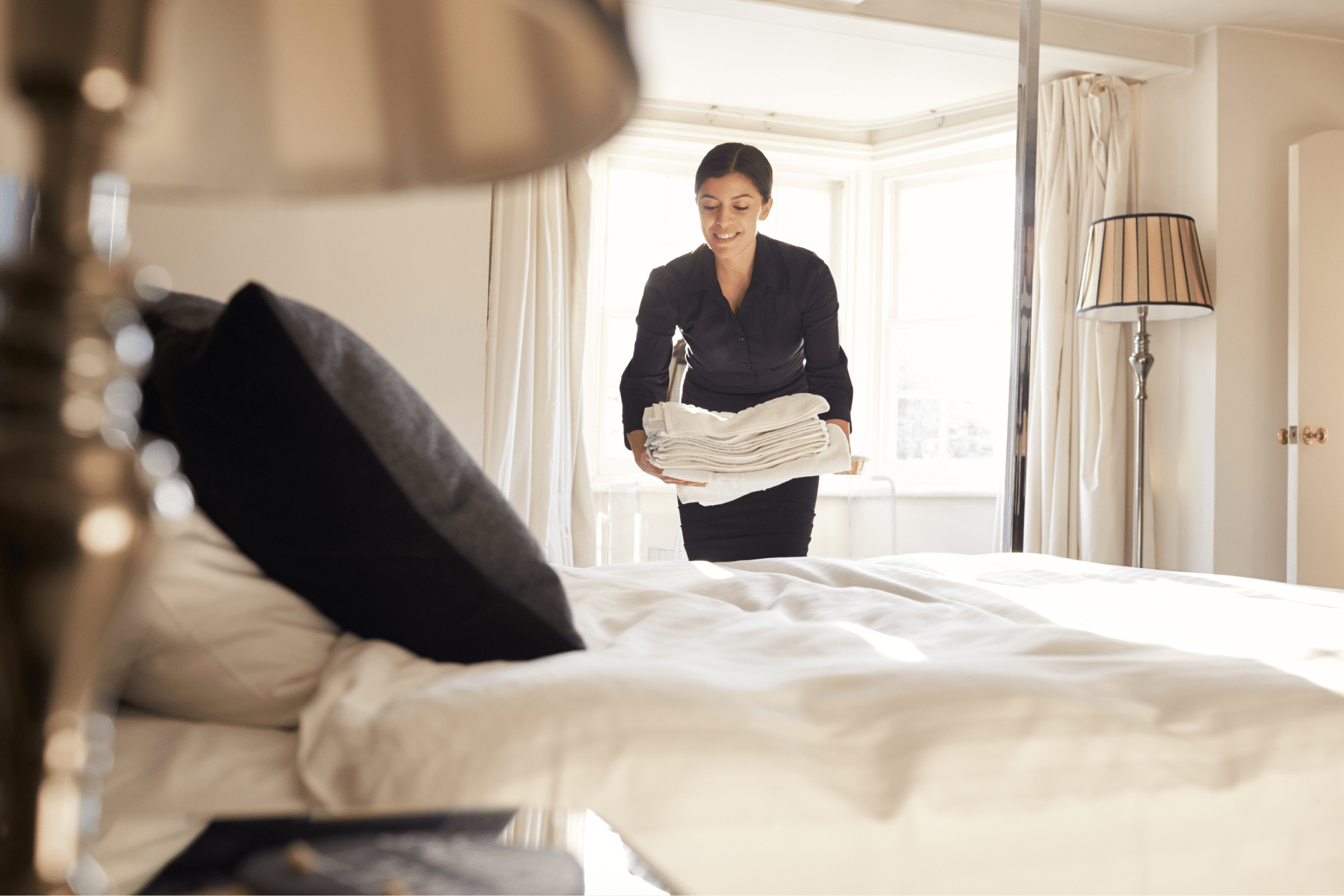 Female housekeeper with clean towels in the hotel room