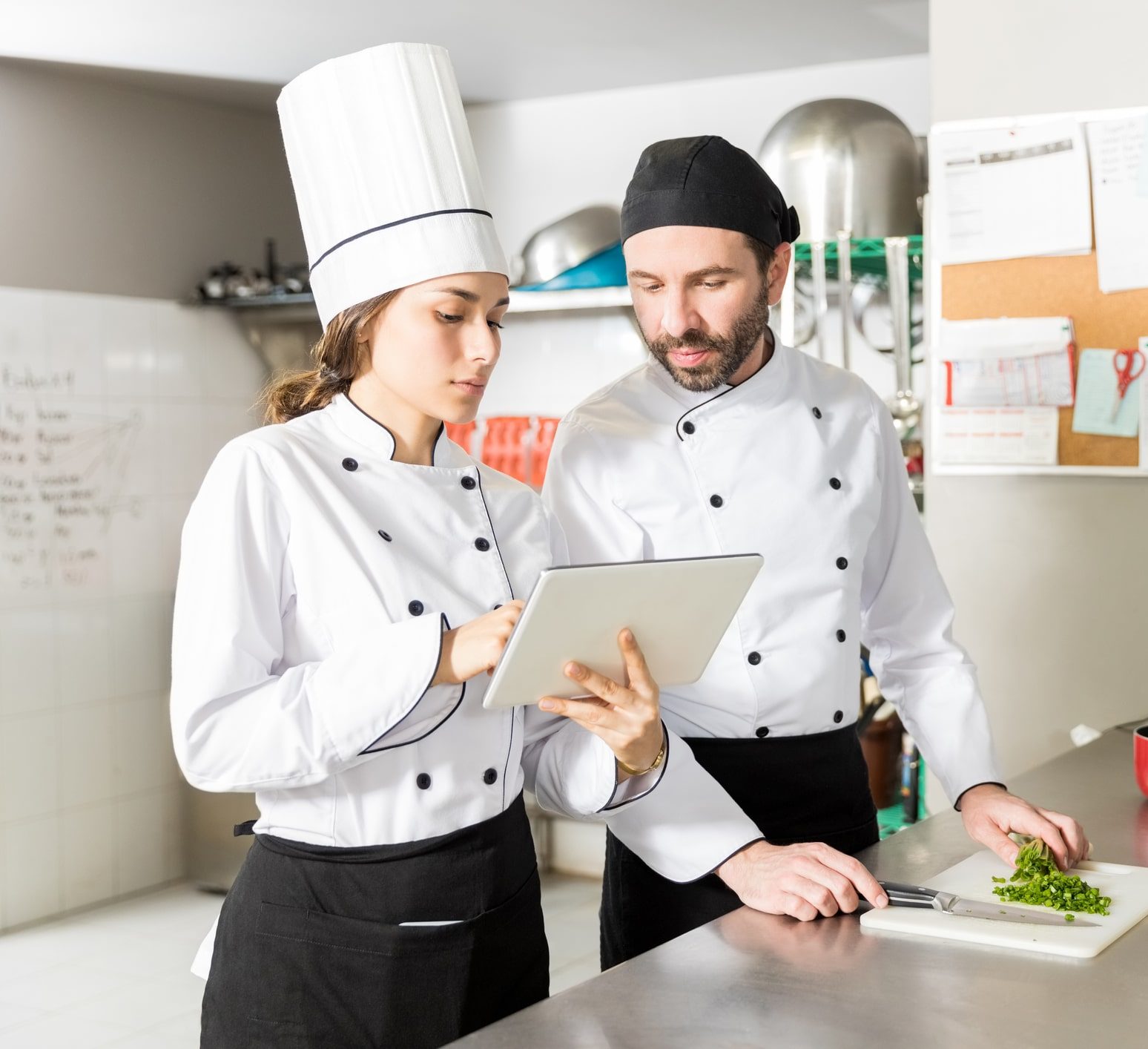 Team of two chefs working at a restaurant and looking at the menu