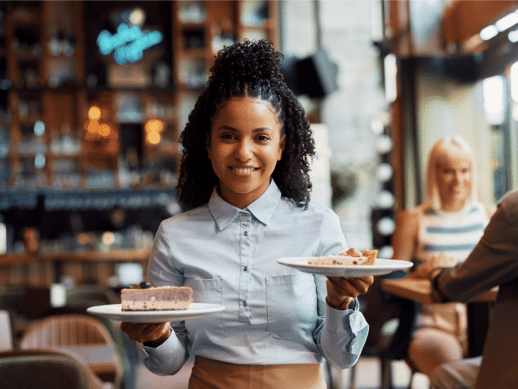 A smiling waitress serving food at a restaurant