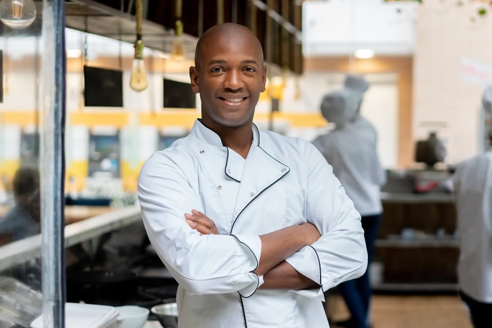 A man standing in a kitchen, working as a caterer