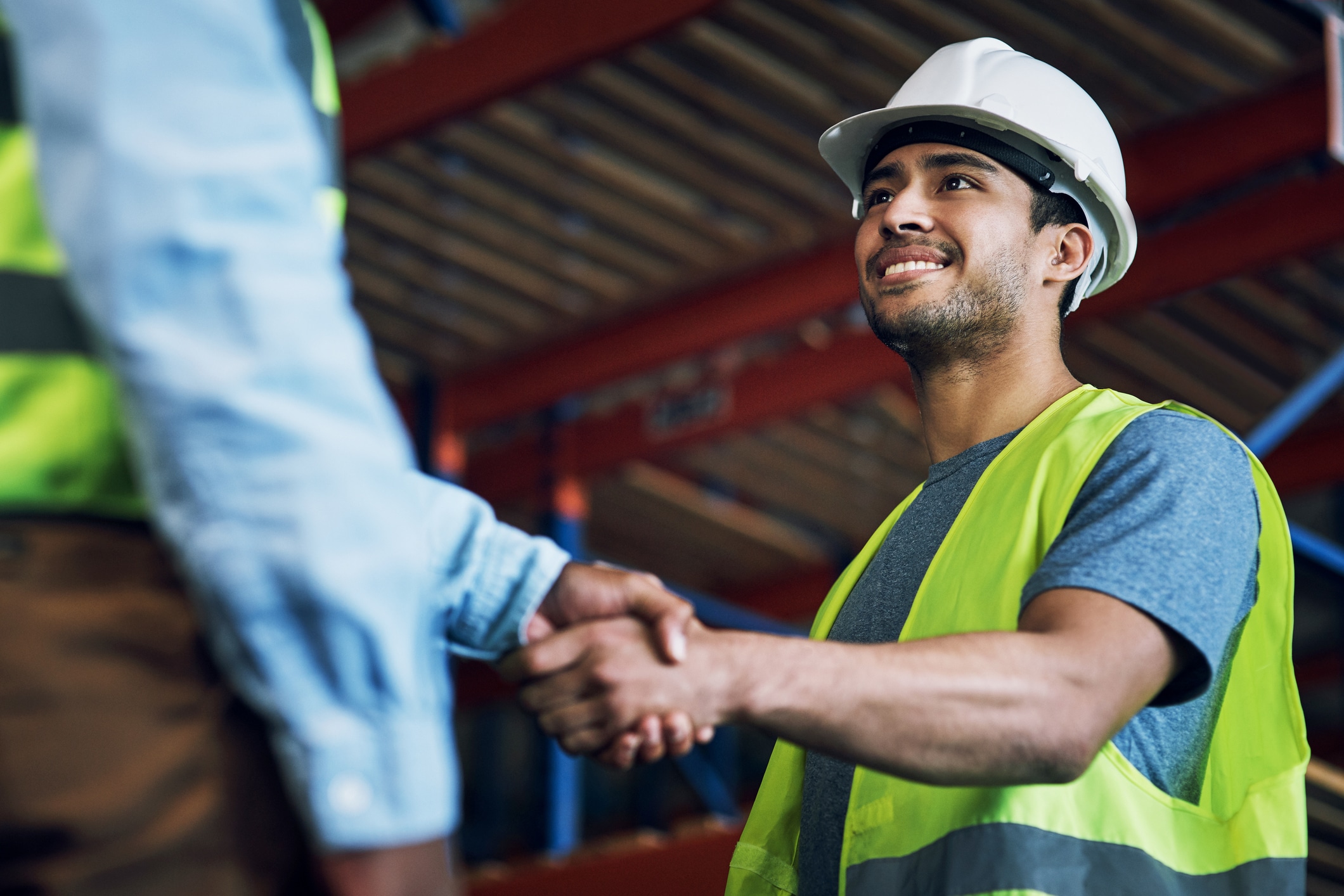 Shot of two warehouse workers shaking hands at a site